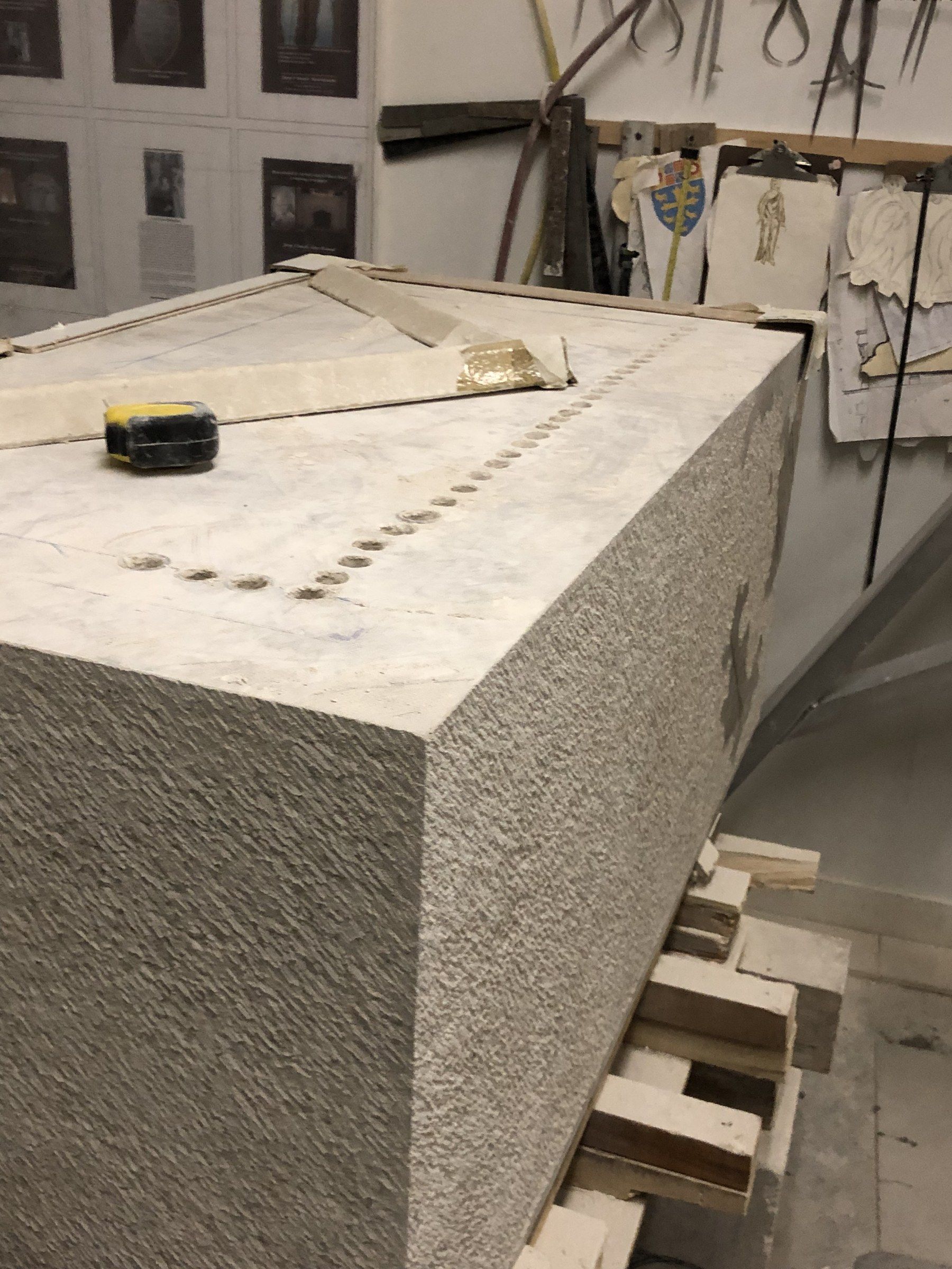 The block before hollowing: its sides with a tooled texture, a line of drilled holes along the top.